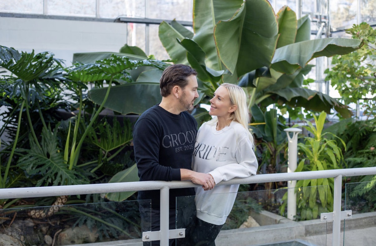 Kendra and Trevor together in bride and groom sweatshirts